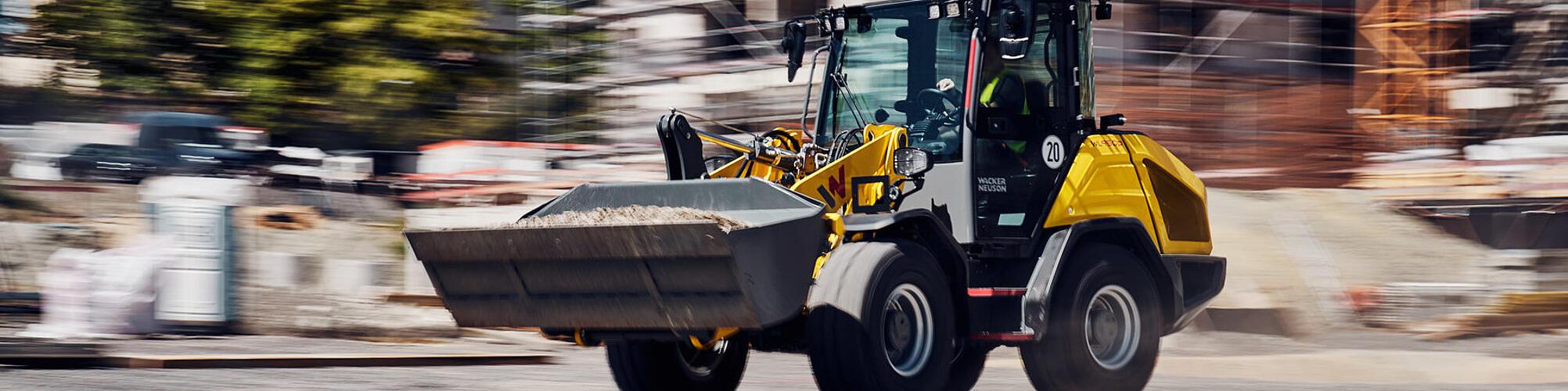 Wacker Neuson WL950p performance wheel loader driving at speed on a construction site.