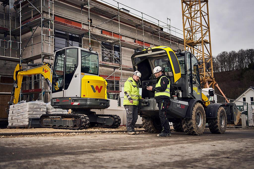 two customers in front of wacker neuson machines