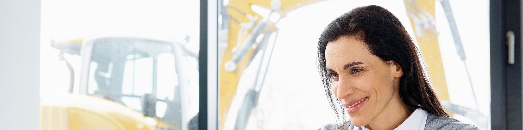 Wacker Neuson employee sitting at a laptop and smiling.