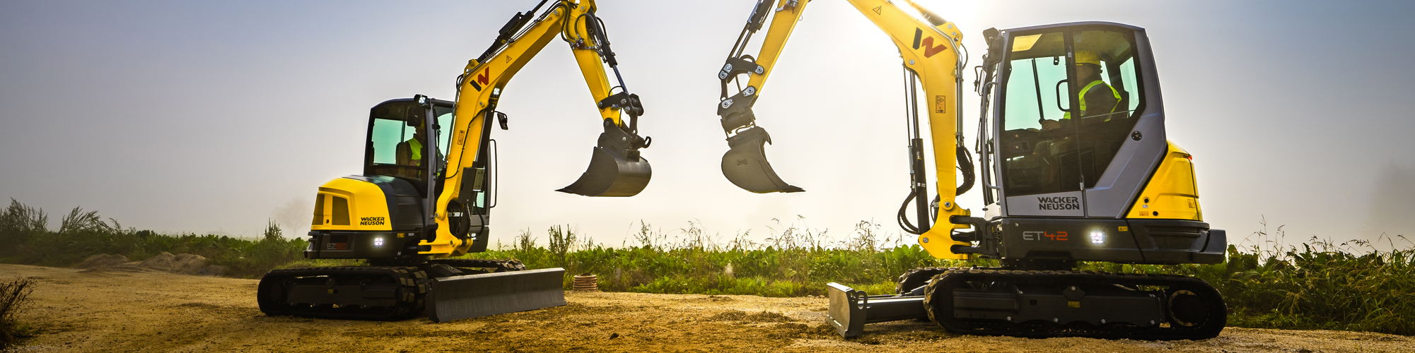Két Wacker Neuson lánctalpas kotrógép áll egy építkezésen.